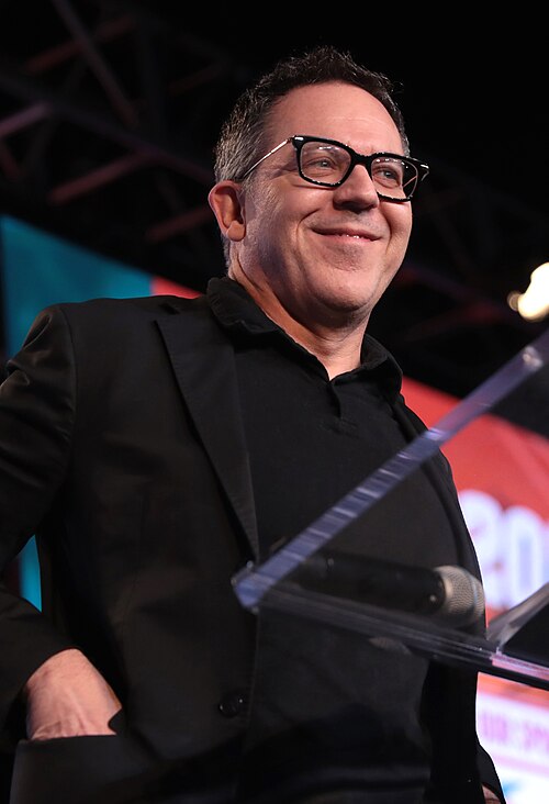 Greg Gutfeld speaking into a microphone in West Palm Beach, Florida, in 2018.