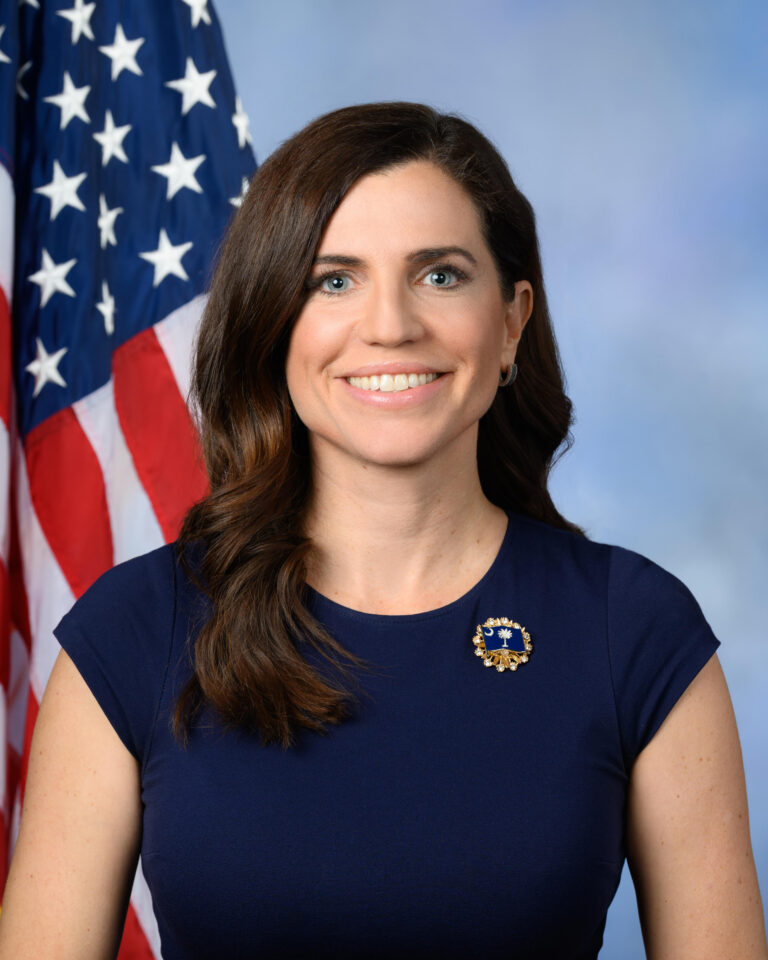 Official congressional portrait of Rep. Nancy Mace, Republican of South Carolina, seated before an American flag.